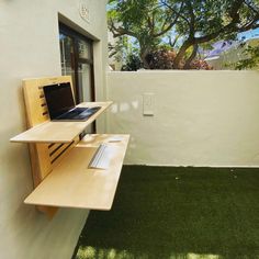 a small balcony with grass and wooden shelves