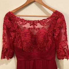 a red dress is hanging on a hanger