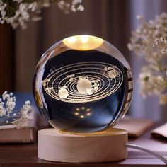 a glass ball with an image of the solar system in it on top of a table