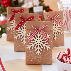 some brown paper bags with snowflakes on them and candy canes in the background