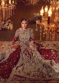 a woman sitting on top of a rug in a room filled with chandeliers