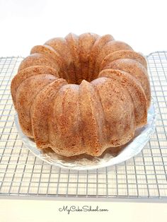 a bundt cake sitting on top of a glass plate next to a cooling rack