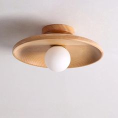 a wooden light fixture with two white balls hanging from it