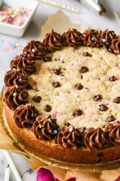 a cake with chocolate frosting and sprinkles on it sitting on a table