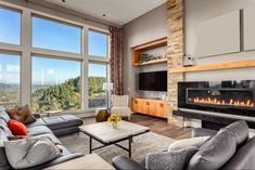 a living room filled with furniture and a fire place in front of a large window