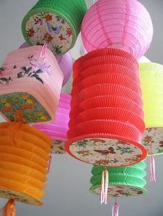 many different colored paper lanterns hanging from the ceiling