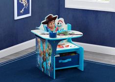 a child's toy table and chair in a room with blue walls, rugs and pictures on the wall