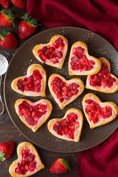 heart shaped strawberry shortbreads on a plate with strawberries next to the plates