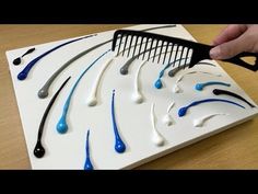 a person is cutting out toothbrushes on a white board with black and blue handles