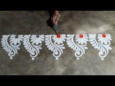 a person is painting on the ground with white paint and red balls in front of them