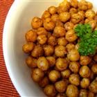 a white bowl filled with chickpeas and garnished with parsley on top