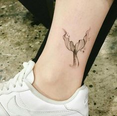 a woman's foot with a flower tattoo on the left side of her leg