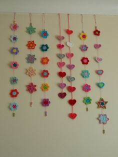 the wall is decorated with many colorful flowers and hearts hanging from it's sides