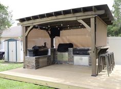 an outdoor kitchen with grill and bar stools