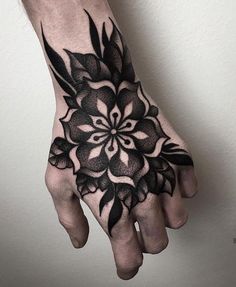 a black and white flower tattoo on the left hand