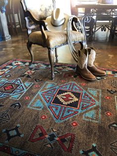 a cowboy hat and boots sit on top of a rug in front of a chair