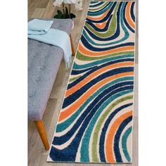 a multicolored area rug on the floor in a living room with a bench