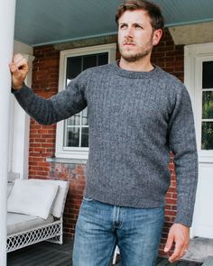 a man standing in front of a brick house