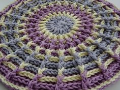 a crocheted dishcloth is sitting on a table top, it looks like an ornament