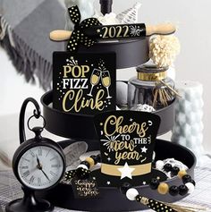 there is a black cake with gold lettering and decorations on the top, along with a clock