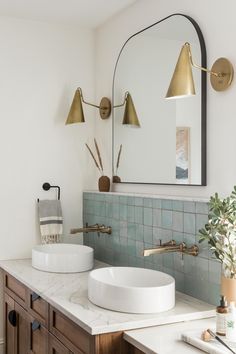 a bathroom with two sinks and a large mirror on the wall next to each other