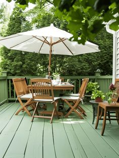 an outdoor table and chairs on a wooden deck