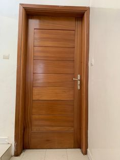 a wooden door in a white room