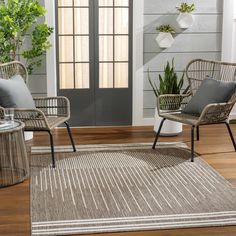 two wicker chairs sitting on top of a wooden floor next to a potted plant