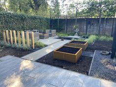 an outdoor garden with wooden planters and gravel