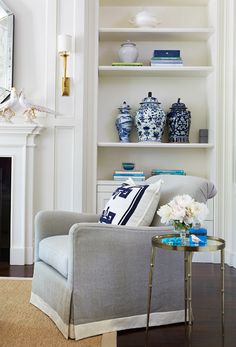 a living room filled with furniture and a fire place in front of a white fireplace