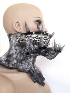 a mannequin's head with horns and spikes on its face is shown