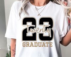 a woman wearing a white shirt with the number twenty three on it and gold lettering