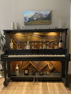 a piano that is sitting in the middle of a room with liquor bottles on it