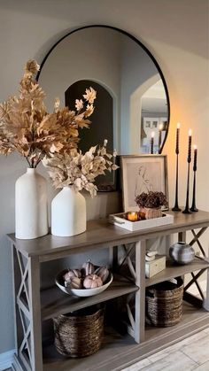 a table with candles, vases and other items on it in front of a mirror