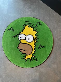 a rug with the face of homer simpson in green and yellow on a wooden floor