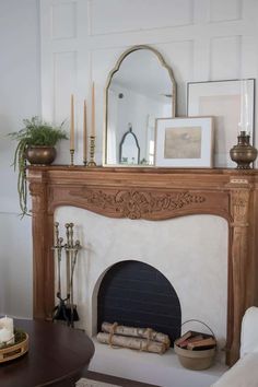 a living room with a fireplace and pictures on the wall above it's mantle