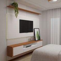 there is a television on the wall in this bedroom with white walls and wood flooring