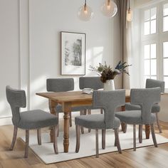 a dining room table with six chairs and a rug on the floor in front of it