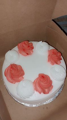 a white cake with pink frosting in a box