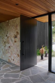 an open door leading to a patio with potted plants