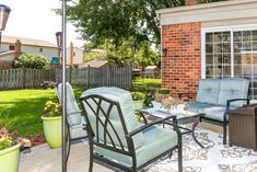 a patio area with chairs, table and umbrella