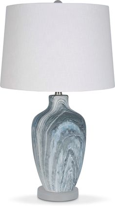 a table lamp with a white shade on the base and a light blue marble design