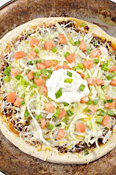 an uncooked pizza sitting on top of a pan covered in cheese and veggies