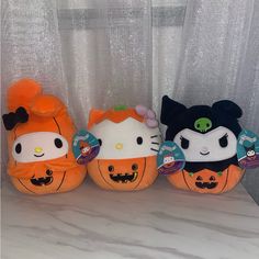 three stuffed pumpkins with hello kitty on them