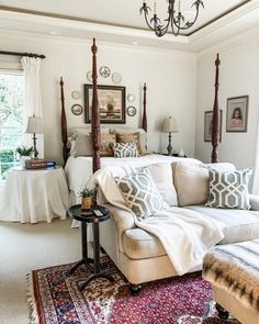 a living room filled with furniture and a chandelier hanging over the top of it