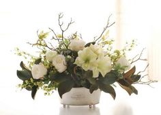 a white vase filled with flowers on top of a table