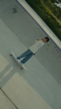 a man riding a skateboard down the side of a cement ramp with graffiti on it