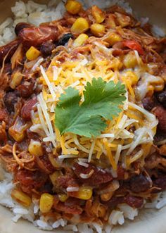 a bowl filled with rice, beans and corn on top of it next to a green garnish