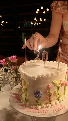 a woman holding a lit candle on top of a cake with the number twenty two