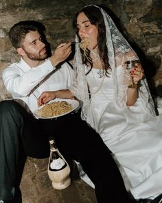 the bride and groom are eating pasta together